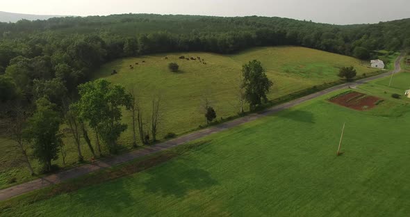 Aerial views of family bicycling along pastoral country roads.