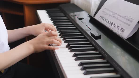 Electronic Piano. Children's Hands on a Keyboard Instrument.