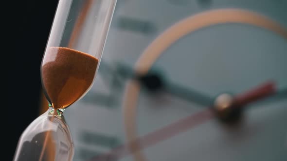 Hourglass Closeup is Pouring Against the Background Ordinary Mechanical Watch