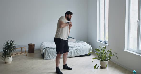 Young Bearded Guy Training at Home, Rotating His Hips