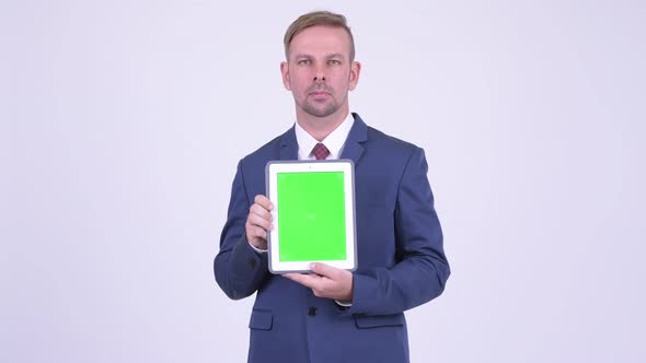 Happy Blonde Businessman Showing Digital Tablet