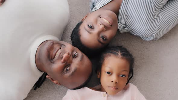 Family Portrait African American Parents with Little Daughter Girl Child Lying on Floor Looking