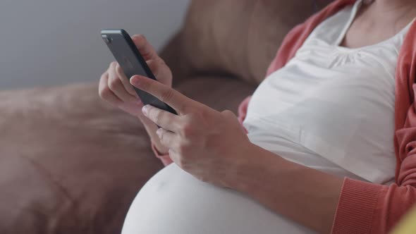 Young Asian Pregnant woman using mobile phone search pregnancy information