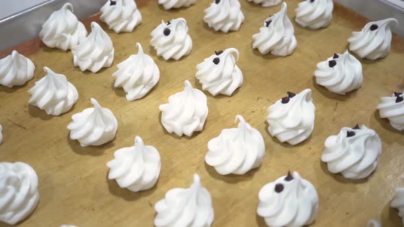 Closeup of Chef Hand Decorating White Meringues Snack with Chocolate Chip in the Kitchen Factory