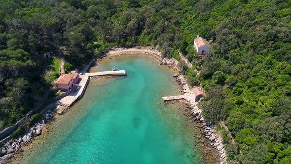 Aerial view of hidden beach surrounding by native forest, Croatia.