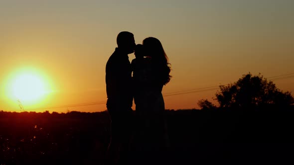 Parents Kiss and Hug Their Baby Unrecognizable Silhouette of a Family at Sunset Family Values