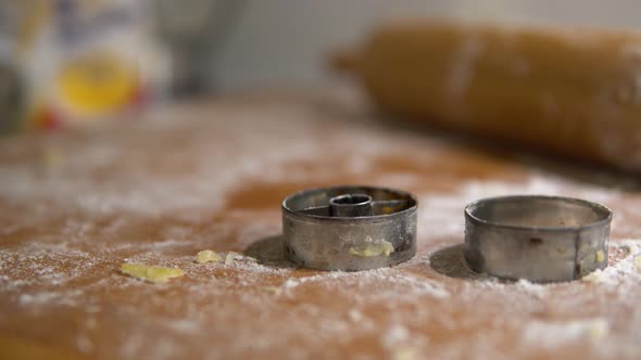 A Close Detail of Cookie Cutters and a Roller on a Table Covered with a Baking Mix.