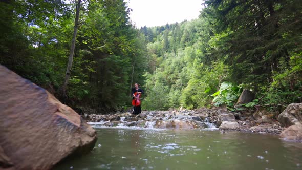 Beautiful woman with cello near the water