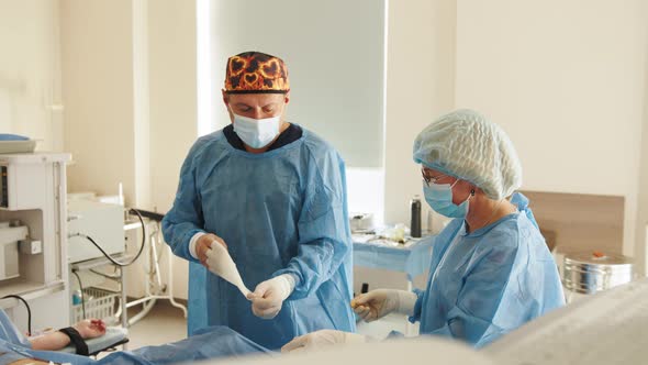 Surgeon Removes and Throws Out the Medical Dressing Gown After the Operation