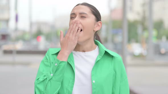 Portrait of Sleepy Hispanic Woman Yawning Outdoor