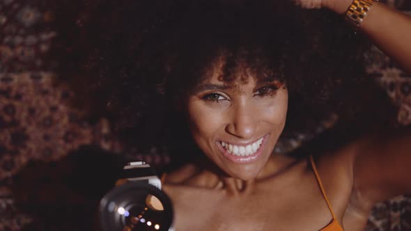 Woman With Afro Hair Smiling With Vintage 8Mm Camera