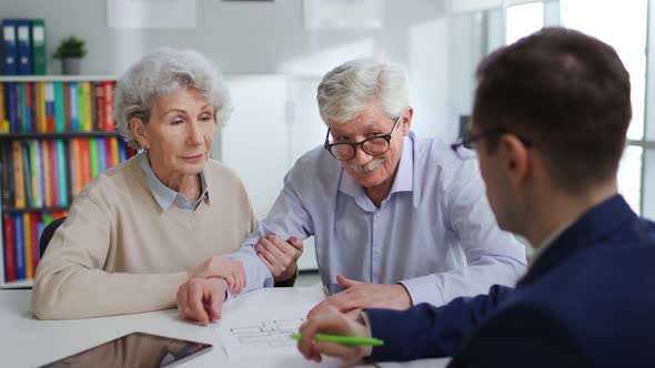 Back View of Insurance Agent Consult Aged Couple