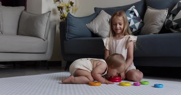 Two Cute Little Caucasian Children Siblings Playing Together with Wooden Toys on Floor at Home