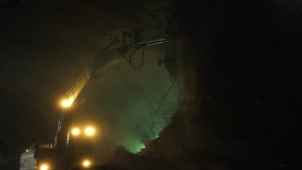 Excavator Breaks Stones in Tunnel