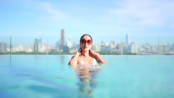 Young asian woman enjoy around outdoor swimming pool for leisure