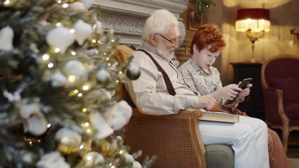 Joyous Boy and Granddad Using Tablet on Christmas