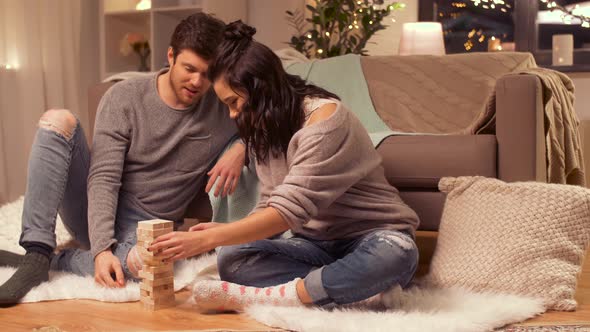 Happy Couple Playing Block-stacking Game at Home