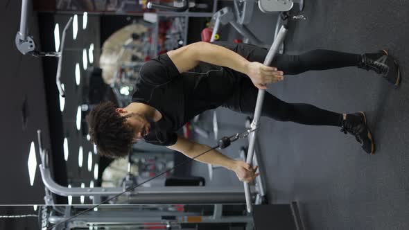 Young Man Exercising on Lateral Pull at Gym for the Back Mucles