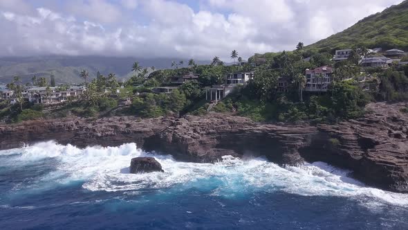 Aerial view of luxurious homes atop rocky cliffs overlooking the ocean