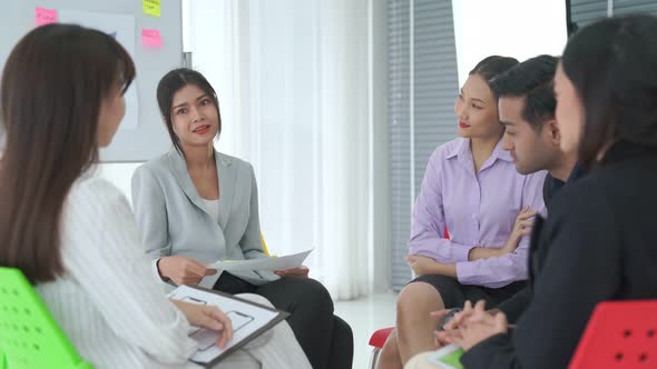 Business People Proficiently Discuss Work Project While Sitting in Circle