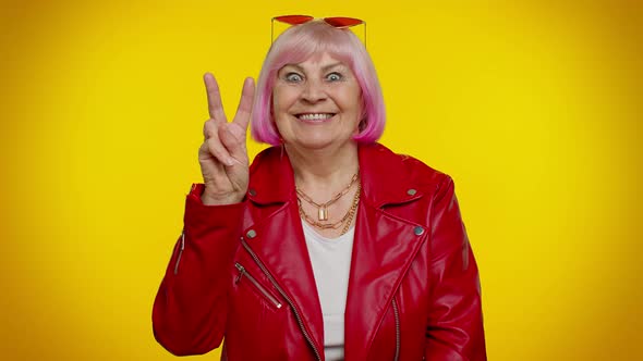 Mature Grandmother Showing Victory Sign Hoping for Success and Win Doing Peace Gesture Smiling