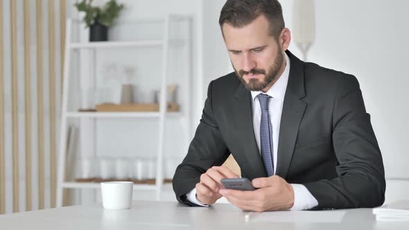 Man Celebrating Success While Using Smartphone