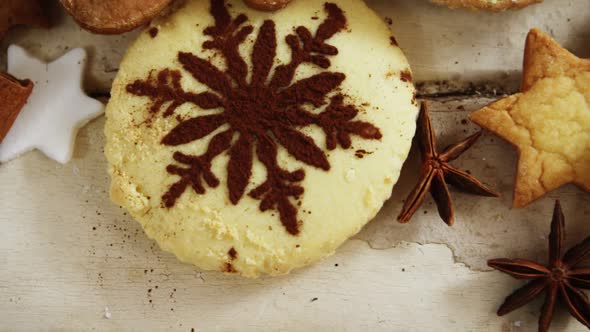 Various christmas cookies and cinnamon on a plank