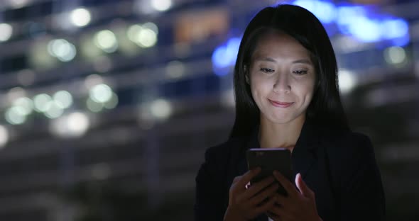 Woman Looking at Mobile Phone in City 