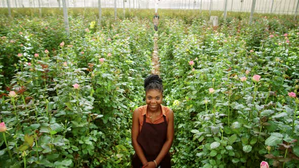 African American Woman Posing for Camera with Smile in Flower Greenhouse