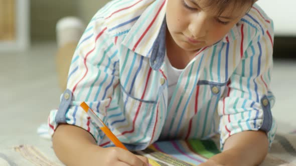 Little Caucasian Boy Drawing Picture with Pencil alt
