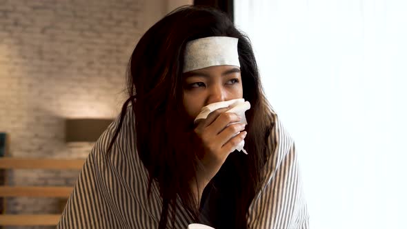 Young Asian Woman Suffering From Cold and Illness and Lying in Bed with Tissue at Home