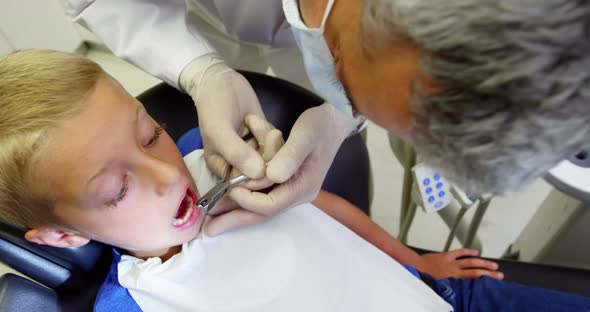 Dentist examining a young patient with tools