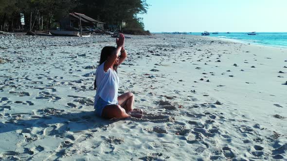 Women tanning on exotic lagoon beach journey by blue sea with white sandy background of Lombok after