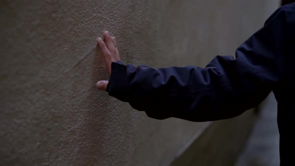 Close-up of a Child's Hand in a Blue Jacket. the Child Walks Down the Street and Touches the Wall of