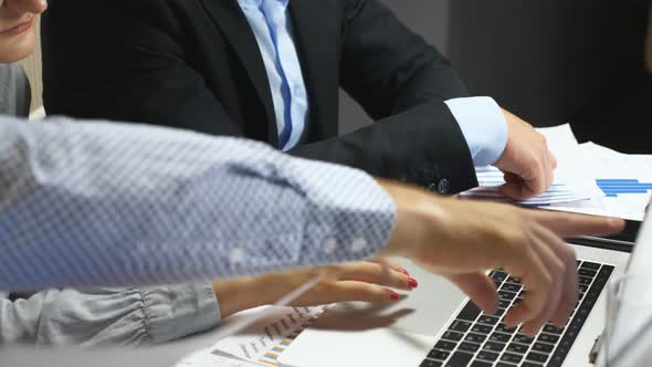 Male Hand of Professional Manager Showing to His Colleagues Financial Reports on Laptop at Office