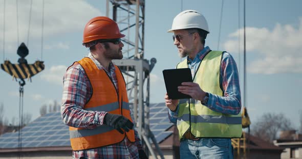 Engineer and Technician Discussing Using Tablet