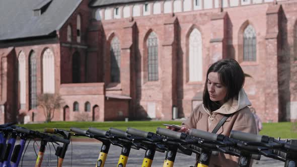 Woman renting electric scooter outdoors