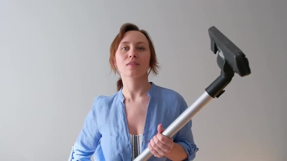 The Girl Lifts the Vacuum Cleaner