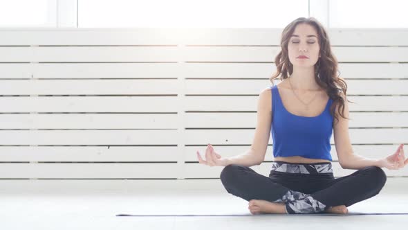 Yoga and Home Workouts Concept Young Woman Meditates While Practicing Yoga Indoors