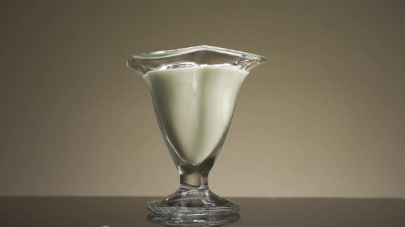 Pouring milk or yogurt into the transparent glass