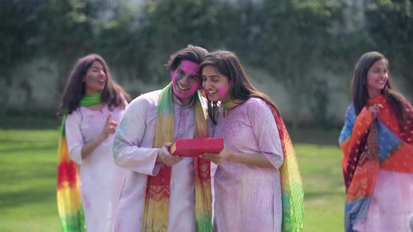Indian woman gifting sweets to her partner on Holi occasion