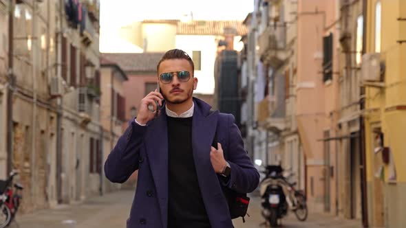 Man Talks and Puts Smartphone Into Coat Pocket on Street