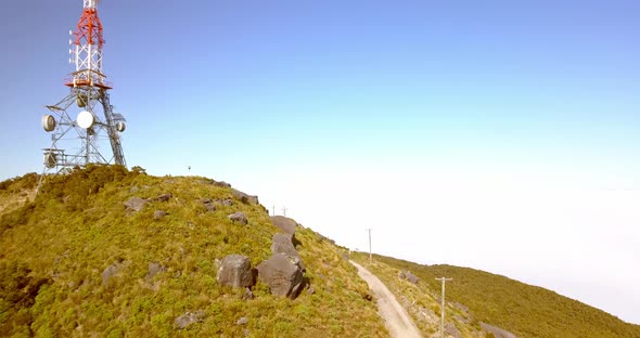 Aerial flypast of the transmission tower on top of Mt Rochfort enveloped in low lying clouds. Locate