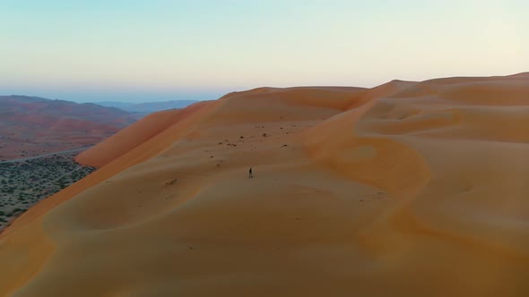 Aerial view of a man walking alone in the top of dunes, U.A.E.