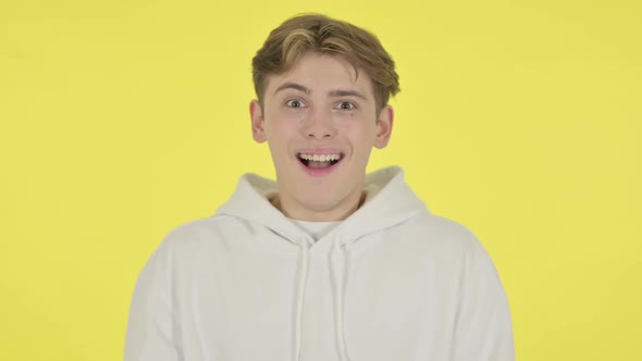 Successful Young Man Celebrating on Yellow Background