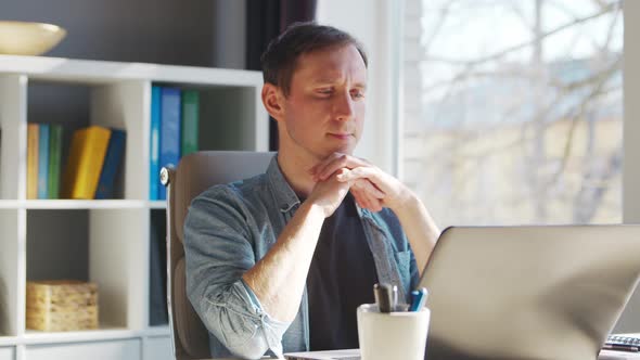 Young male entrepreneur works at home office at the computer.