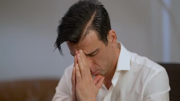 Closeup Portrait of Exhausted Sad Middle Eastern Man Holding Hands Together Thinking