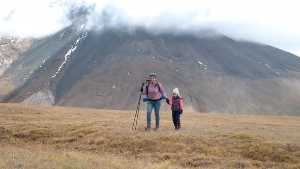 Mother with Little Daughter Hiking in Mountains