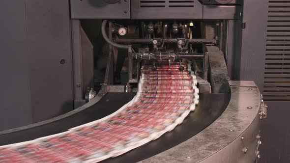 Printed newspapers moving on conveyor zooming out