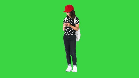 Casual School Girl Check Her Email with a Mobile Phone on a Green Screen Chroma Key